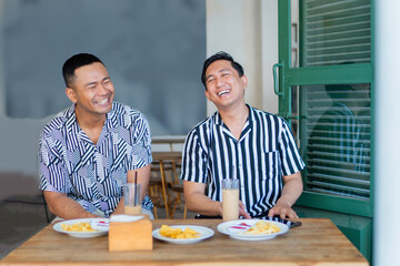 Two friends enjoying food and laughter in a vibrant caf atmosphere