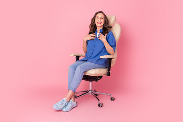 Full length photo of lovely senior lady sit armchair laugh touch chest dressed stylish blue garment...