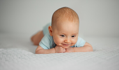 Portrait of a Little Baby Boy Lying on his Stomach and Wearing a Blue Suit.