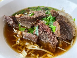 Stewed beef with gravy sauce style chinese food on top noodles. Selective and focus. Shooting in studio, Clean food good taste idea concept.