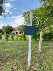 blank  notice board on garden of village house in a rural area