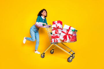 Full size photo of lovely young lady shopper push cart pile gifts dressed stylish striped garment...