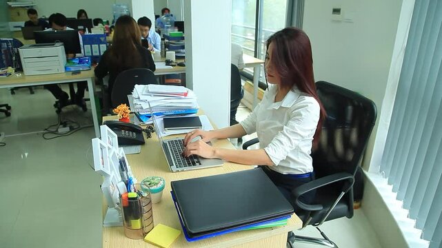 Woman working with laptop in office and Senior Admin Officer writing a report about two young annoying colleagues chit-chatting during work hours, 4k Video