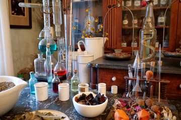 Chemistry flasks with liquids, herbs of medicinal plants in an old pharmacy