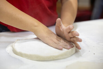 Close up shot of woman's hands kneading pizza dough
