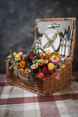 Fototapeta na wymiar Close-up. A wicker picnic basket with a bouquet of dried autumn flowers.
