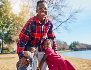 Fototapeta premium Children, boys and girl with hug, portrait and field for fun and playing in park. Vacation, black family and siblings with smile, together and bonding for summer holiday with nature and confidence