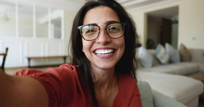 Close up face of pretty woman in glasses look at smartphone cam, making video call, record video for social media, socialize, enjoy pleasant communication remotely use videocall application, vlogging