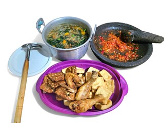 Traditional Indonesian dishes include spinach with side dishes of fried chicken, fried tofu, fried tempeh and traditional chili sauce