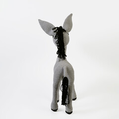 Amigurumi doll gray donkey stands background white isolated