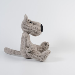Amigurumi doll wolf gray sits there white isolated
