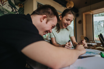 A young boy with Down syndrome and a girl in a wheelchair happily engage in creative drawing and painting activities together, fostering friendship and inclusion.