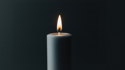 .Black candle on black background. Lighted candle is a symbol of mourning, empathy, memory and hope. Minimalist photo of a black candle.