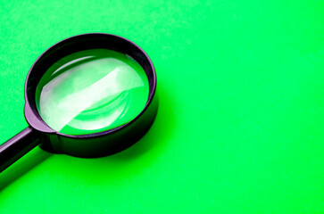 Magnifying glass on green cover background with customizable space for text or ideas