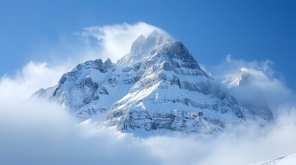 Obraz premium Majestic Snow-Covered Mountain Peak Emerges Through Clouds