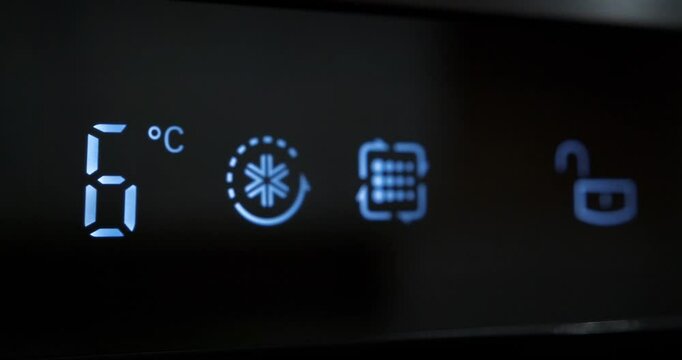 Decreasing the temperature on the digital display of the refrigerator. Adjusting temperature of refrigerator on kitchen. Reducing temperature to zero degrees Celsius. Cinema 4K 60fps video