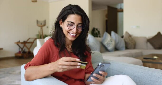 Beautiful Latina woman making online purchases using credit card and smartphone, enjoy convenience and accessibility of online shopping through marketplace application. Digital payments, e-commerce