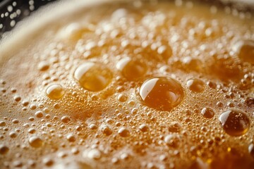 Close-up of a dark, frothy beverage with rich bubbles rising on the surface, creating a textured and foamy appearance.