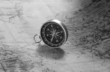 Classic round compass on background of old vintage map of world
