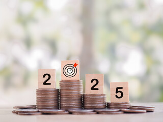 Wooden blocks with the number 2025 on stack of coins. The concept of saving money, Financial, Investment and Business growing in year 2025.