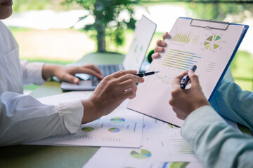 Reviewing sustainability reports and environmental performance charts in business meeting....