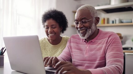 Fototapeta premium Elderly couple using laptop at kitchen table, bright lighting, clean background, copy space