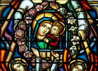 2024-08-01, Paris, FRANCE. Stained glass of Blessed Virgin Mary holding baby Jesus Christ in her arms. .