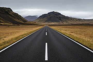 Empty road leading through dramatic mountains under a moody sky.