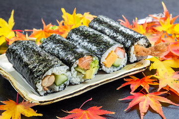 japanese cuisine sushi rolls on a background of autumn leaves