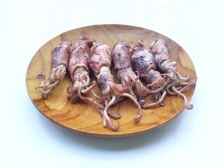 grilled chopsFresh salted squid on a wooden plate isolated on white background. food ingredient, raw sea food 