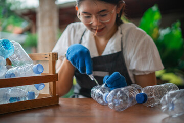 blurred photo woman cutting plastic bottle to make handmade craft, recycle concept