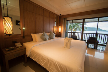 Interior of modern bedroom at hotel with white bed and pillow.
