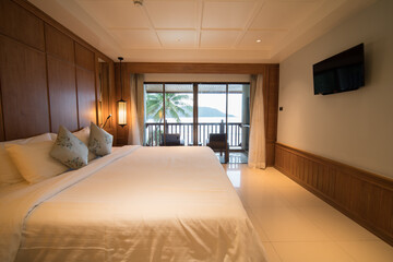 Interior of modern bedroom at hotel with white bed and pillow.