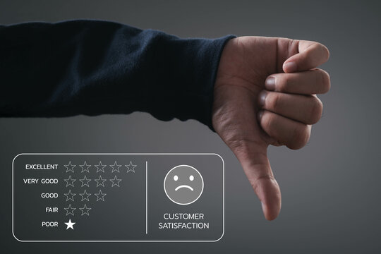 Hand giving a thumbs down next to a poor customer satisfaction rating, highlighting negative feedback.