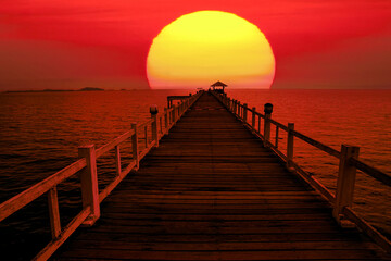 Obraz premium Wooden bridge on the sea on the background of the rising sun