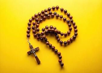 Aerial View of Christian Rosary on Vibrant Yellow Background for Spiritual Themes and Text Space