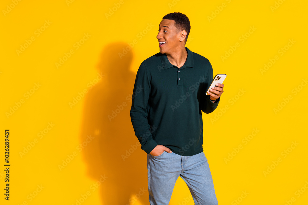 Canvas Prints Photo of nice young man hold phone look empty space wear pullover isolated on bright yellow color background