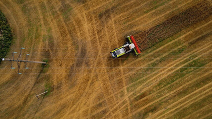 Aerial view of a combine harvester working in a field.