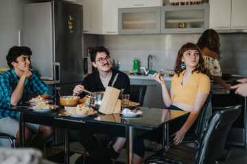 A group of friends sitting around a dining table, sharing a meal in a stylish kitchen. The atmosphere is relaxed and cheerful, capturing the essence of social dining.