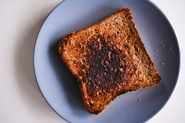 Burnt slice of toast bread isolated on white with text space