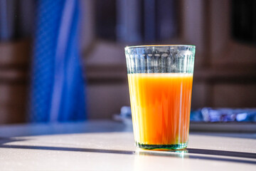 Fruit juice on the breakfast table in the morning sunlight