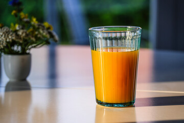 Fruit juice on the breakfast table in the morning sunlight