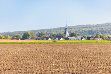 Panorama of a landscape with hills and village where the church spire protrudes