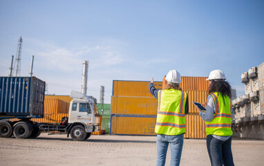 Engineer or worker team are standing forklift or truck vehicle are working appear discussing or reviewing document, likely related inspect container factory and industry transportation import export.