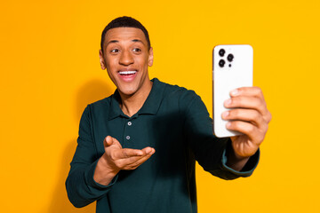 Photo portrait of nice young male talking video call wear trendy green outfit isolated on yellow color background