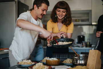A group of friends serving and enjoying a meal together in a cozy kitchen. The atmosphere is warm...