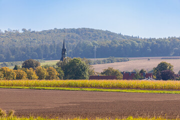 Panorama of a landscape with hills and village where the church spire protrudes
