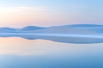 Fototapeta premium Sand dunes reflected in calm water at sunrise, creating a serene desert landscape with soft pastel colors and a minimalist composition