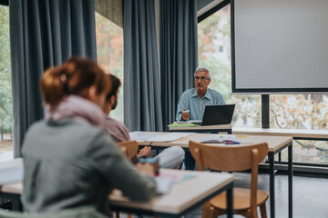 A group of students in a cozy classroom attentive to an instructor. The setting is modern with natural lighting and an engaging learning atmosphere.