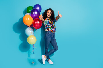 Fototapeta premium Photo of cheerful glad cute girl wear stylish clothes helium balloon thumb up offer empty space isolated on blue color background
